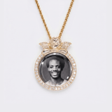 The front side of CRNCY's regular size Angel Photo Pendant with a 14k gold finish. The front side features prong-set diamonds around the photo, angel, and bale. The front side shows the customer's photo selection.