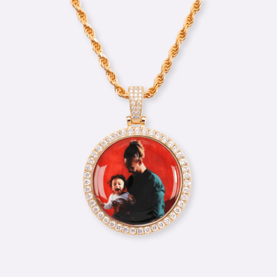 The front side of CRNCY's Classic Photo Pendant with a 14k gold finish. The front side features prong-set diamonds around the photo and on the bale. The front side shows the customer's photo of choice.