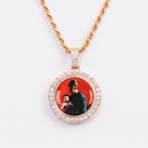 The front side of CRNCY's Double Sided Photo Pendant with a 14k gold finish. The front side features prong-set diamonds around the photo and on the bale. The front side shows the first photo choice.