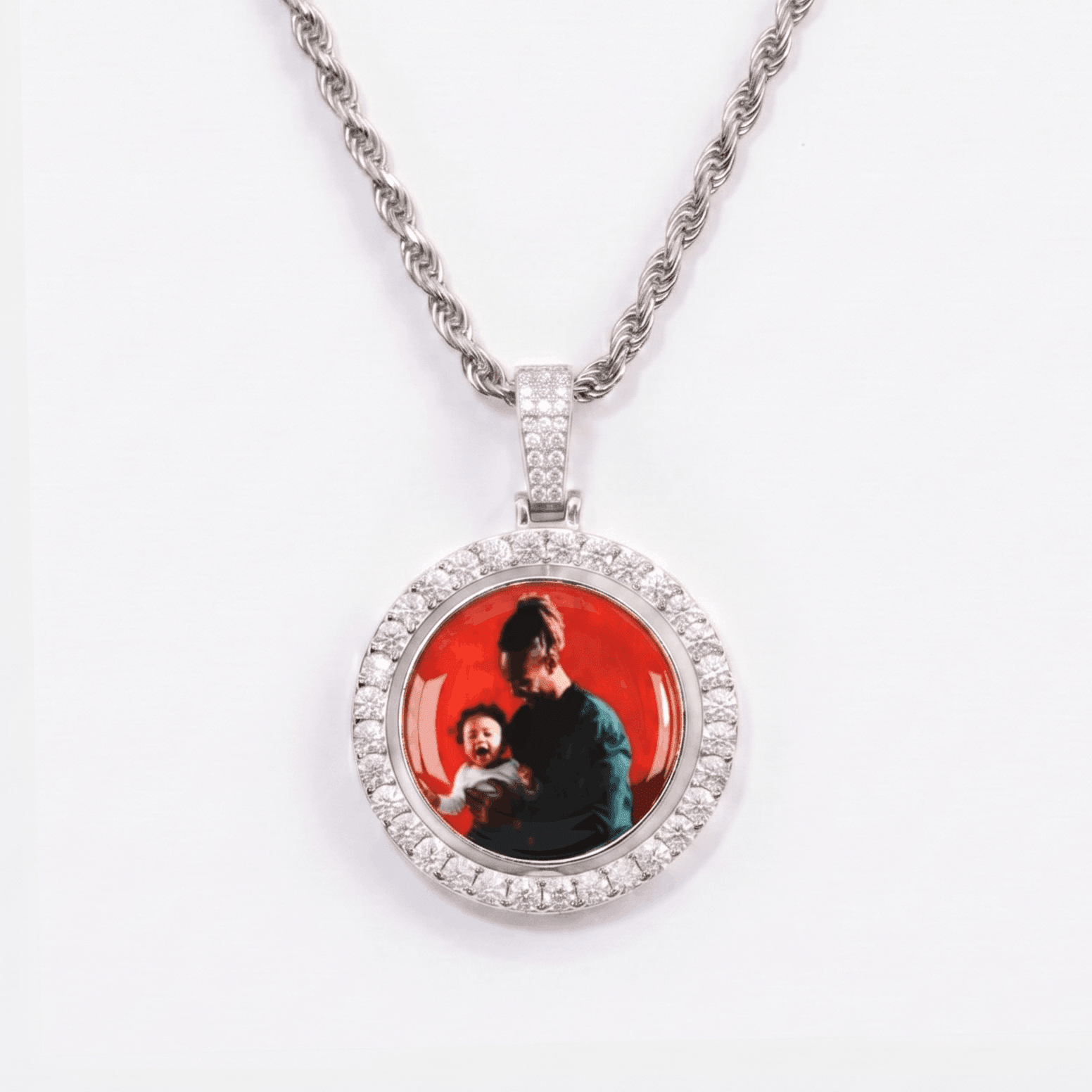 The front side of CRNCY's Double Sided Photo Pendant with a silver finish. The front side features prong-set diamonds around the photo and on the bale. The front side shows the first photo choice.