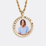 The front side of CRNCY's Forever With Me Photo Pendant with a 14k gold finish. The front side features a polished border around the photo. "Forever With Me" is engraved on the upper half of the photo pendant, filled with black jewelry enamel. The front side shows the customer's photo selection. 
