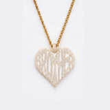 The front side of CRNCY's Brother Heart Photo Pendant with a 14k gold finish. The front side features prong-set diamonds placed inside each letter, surrounded by colored jewelry enamel to outline the letters. 