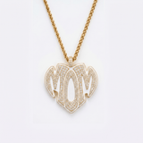 The front side of CRNCY's Mom Heart Photo Pendant with a 14k gold finish. The front side features prong-set diamonds placed inside each letter, surrounded by colored jewelry enamel to outline the letters. 