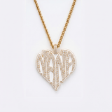 The front side of CRNCY's Nana Heart Photo Pendant with a 14k gold finish and white jewelry enamel. The front side features prong-set diamonds placed inside each letter, surrounded by colored jewelry enamel to outline the letters. 