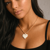 Female model wearing CRNCY's Sister Heart Photo Pendant with a 14k gold finish and a 18 inch length necklace.
