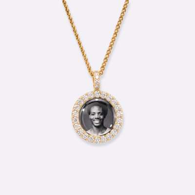 The front side of CRNCY's Mini Iced Photo Pendant with a 14k gold finish. The front side features prong-set diamonds around the photo and on the bale. The front side shows the customer's photo selection.