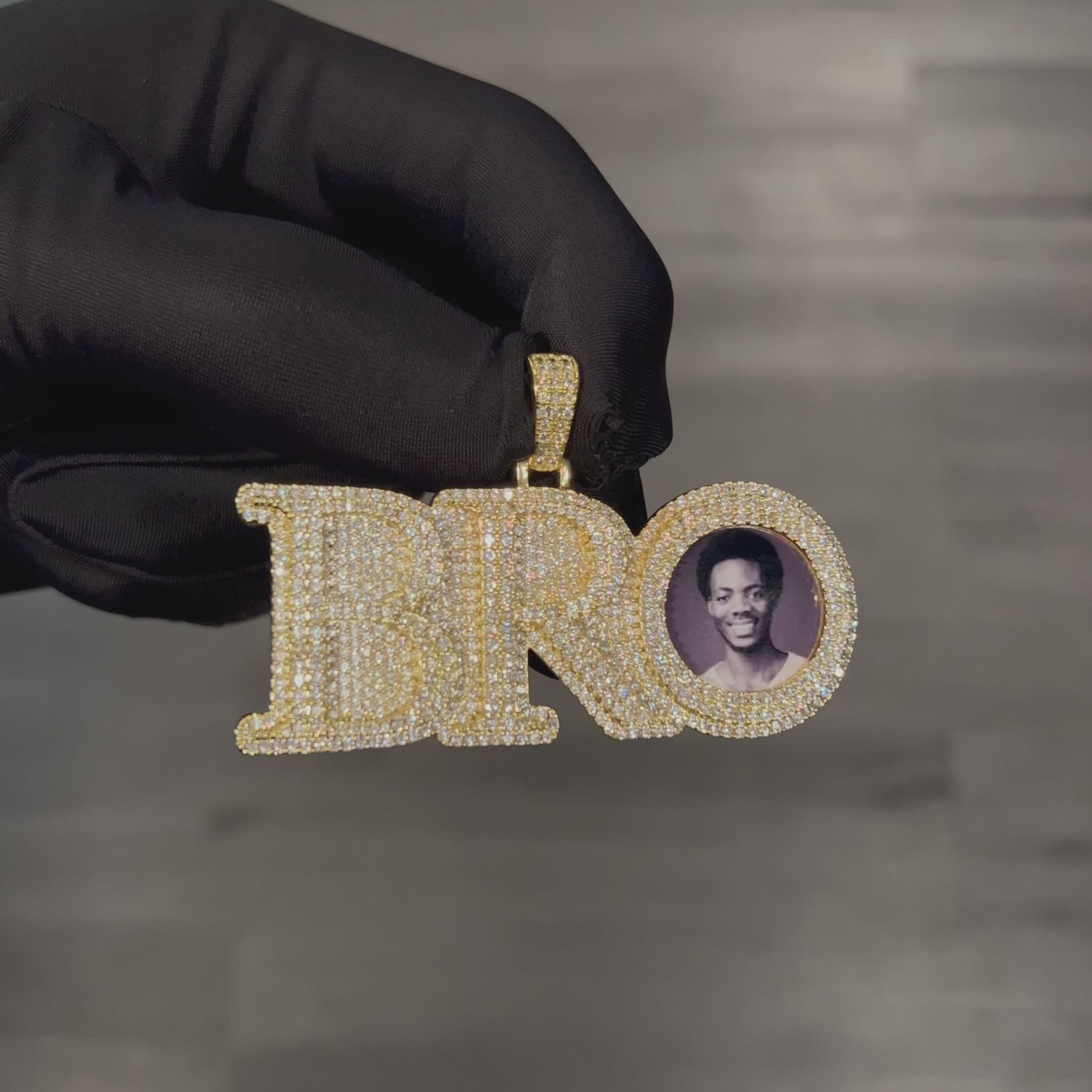 Close up video of CRNCY's Large size BRO Photo Pendant with a 14k gold finish. The video showcases the pendant's details and diamond clarity.