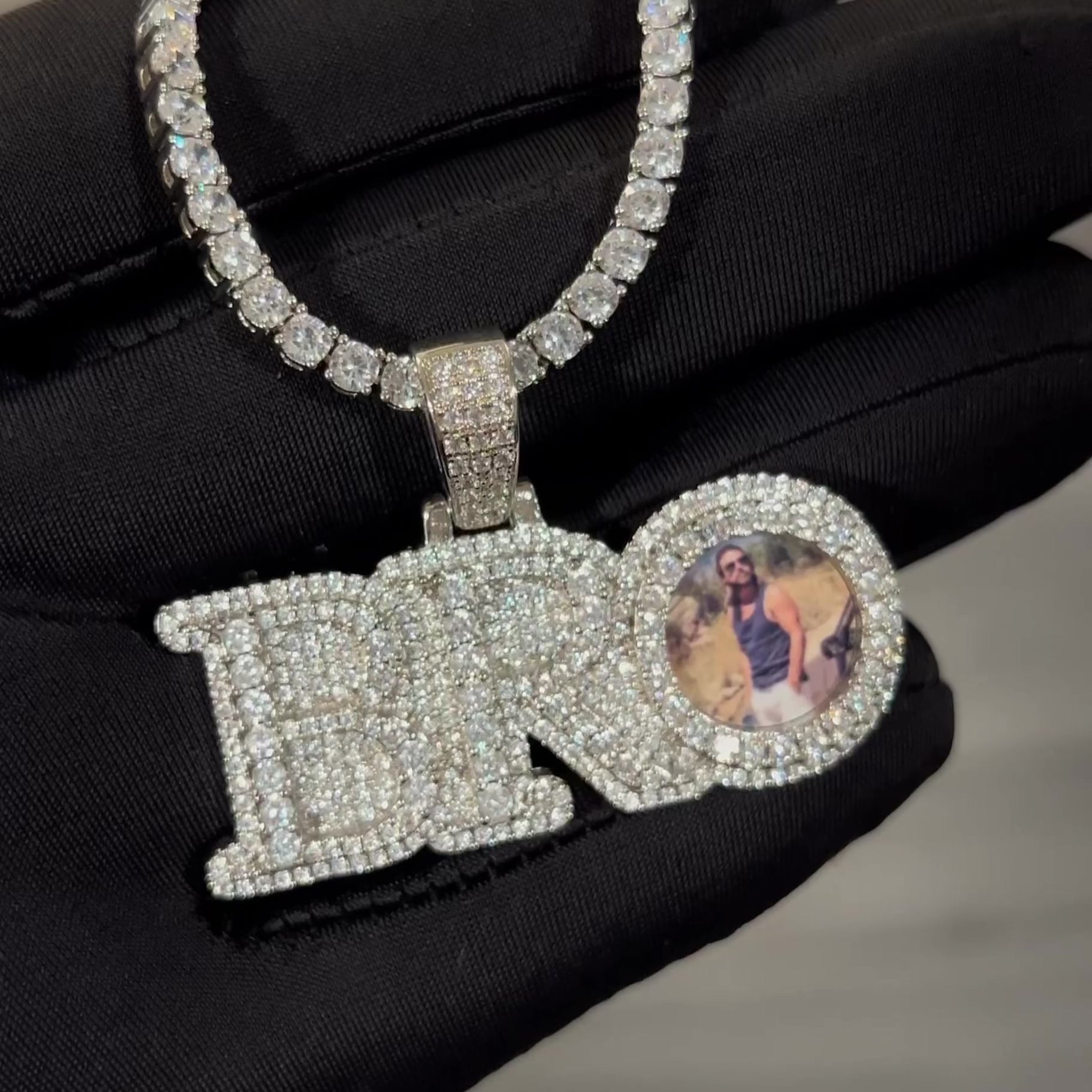 Close up video of CRNCY's small sized BRO Photo Pendant with a silver finish. The video showcases the pendant's details and diamond clarity.