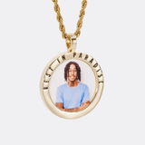 The front side of CRNCY's Rest In Paradise Photo Pendant with a 14k gold finish. The front side features a polished border around the photo. "Rest In Paradise" is engraved on the upper half of the photo pendant, filled with black jewelry enamel. The front side shows the customer's photo selection. 