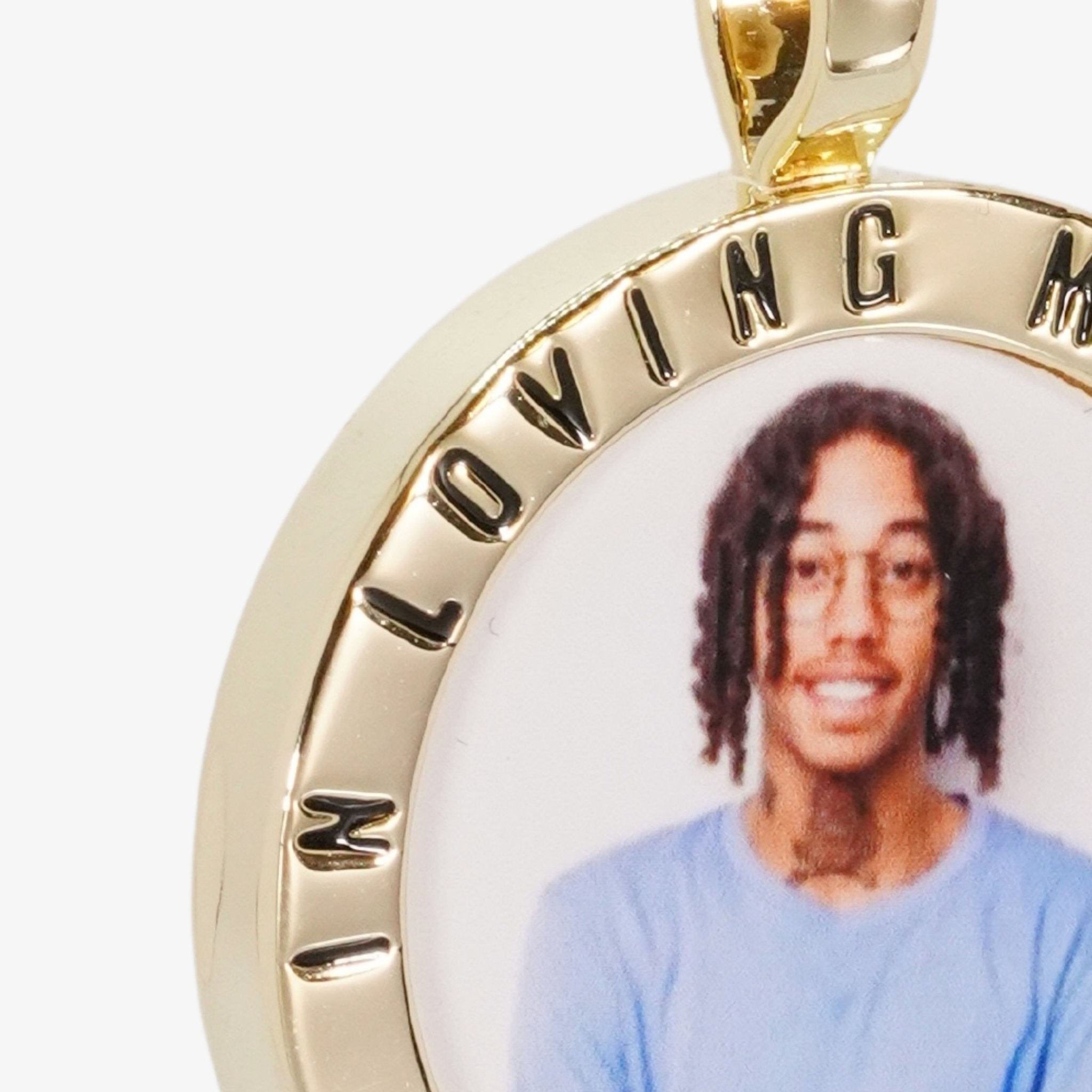 Close-up image of CRNCY's In Loving Memory Photo Pendant. Focusing on the engraved words on the top of the photo pendant.