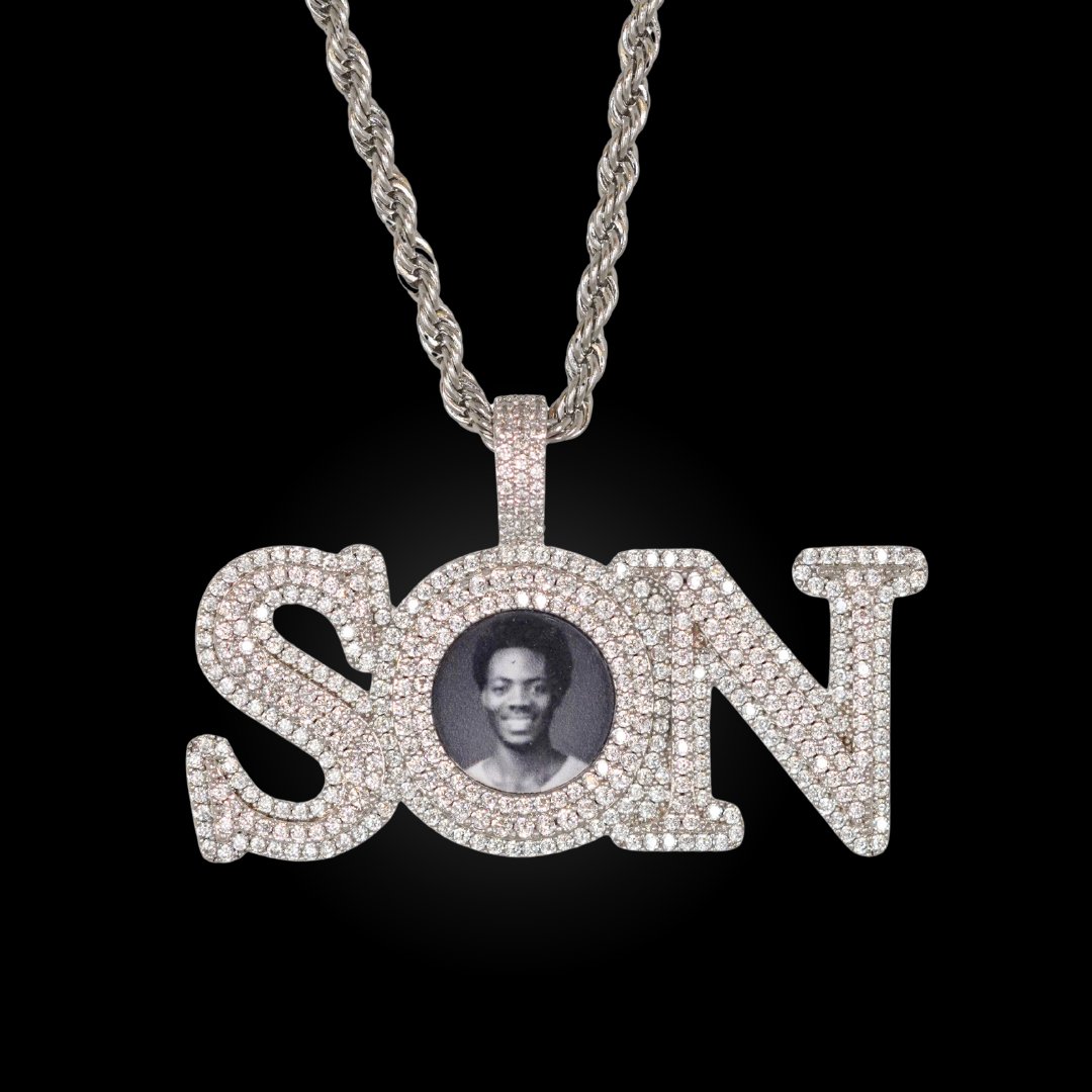 The front side of CRNCY's SON Photo Pendant with a silver finish. The front side features prong-set diamonds around the photo and on the bale. The front side shows the customer's photo selection.